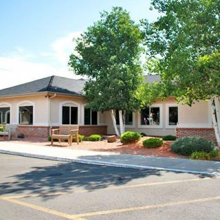 A commercial building with a landscaped area and parking lot in front.