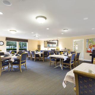 A well-lit dining area with neatly arranged tables and chairs.