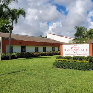 A well-maintained building with vibrant landscaping under a cloudy sky.