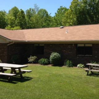 A brick building with picnic tables on a sunny day.