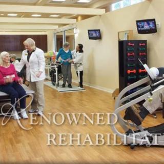 A rehabilitation facility with exercise equipment and medical staff assisting patients.