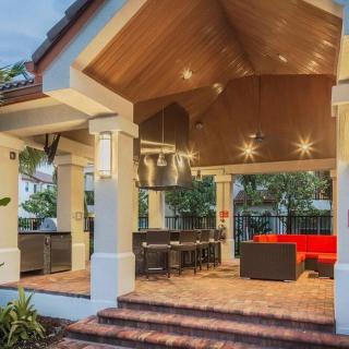 A cozy outdoor patio with a pergola, stylish furniture, and elegant lighting.