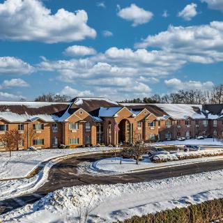 A scenic view of a building surrounded by snow under a cloudy sky.