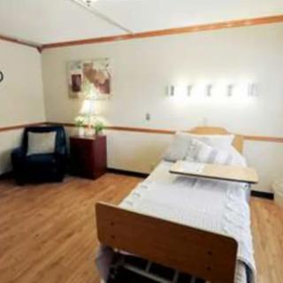 A clean and organized hospital room with a single bed and medical equipment.