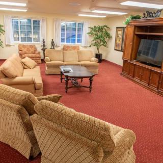 A cozy living room with plush sofas, a large TV, and warm lighting.