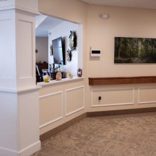 Interior view of a reception area with a counter and artwork on the wall.