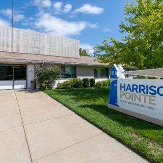 The entrance to the Harrison Pointe building, featuring clear signage and a landscaped pathway.