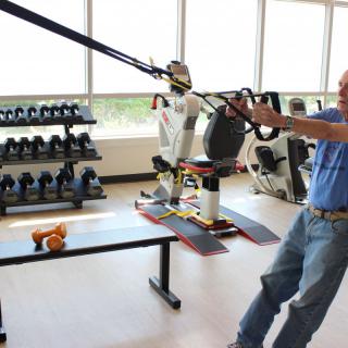 A person participating in a physical therapy session using exercise equipment in a fitness center.