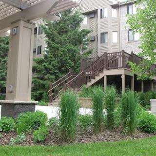 An apartment building with surrounding greenery and outdoor stairs.
