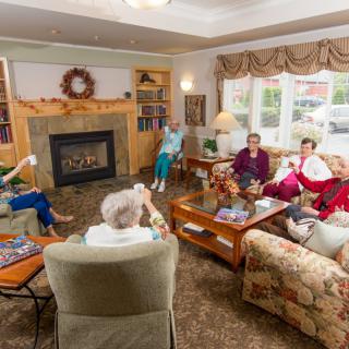 A group of seniors relaxing and conversing in a cozy living room setting.