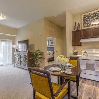 A modern apartment interior featuring an open living room, dining area, and kitchen.