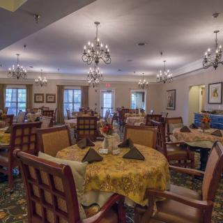 An elegant dining room with chandeliers and neatly arranged tables.