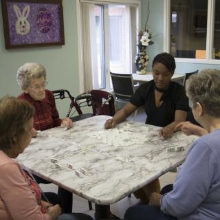 A group of people sitting at a table indoors, engaged in conversation.