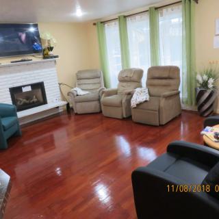 A cozy living room with comfortable chairs, a fireplace, and a television.