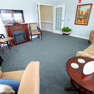 A cozy living room featuring a fireplace, television, and comfortable seating.
