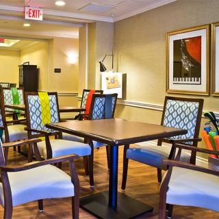 A modern dining area with colorful chairs and artwork adorning the walls.