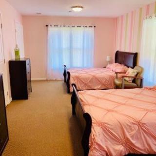 A spacious bedroom with twin beds and pink decor.