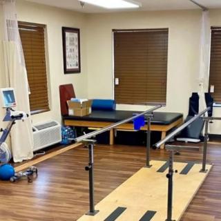 A physical therapy room equipped with parallel bars and exercise equipment.