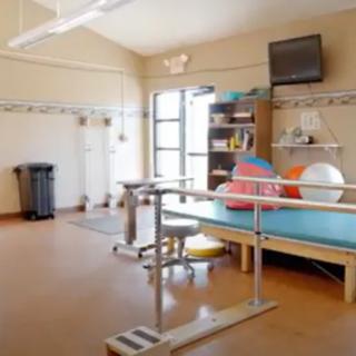 A rehabilitation room equipped with exercise equipment and therapy tools.