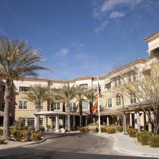 A modern hotel featuring a serene entrance surrounded by palm trees.