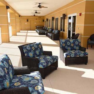 A spacious outdoor patio with comfortable seating and vibrant cushions on a sunny day.