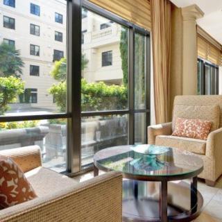 A modern living room featuring comfortable seating with large windows providing ample natural light.