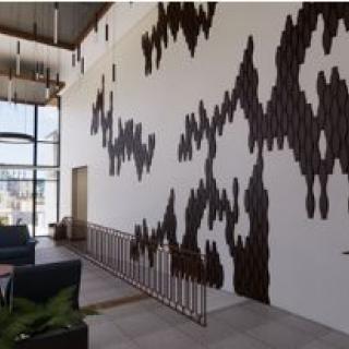 A modern lobby featuring unique wooden wall art and contemporary lighting.