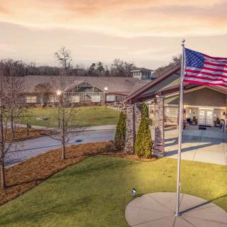A scenic view of a building with an American flag flying at sunset.