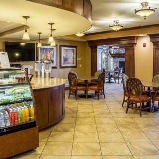A cozy cafe interior with a seating area, beverage display, and modern lighting.