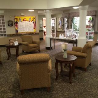 A cozy lobby area with armchairs and tables arranged in a welcoming setting.