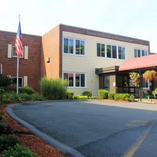 A school building with an entrance, American flag, and well-maintained landscaping.