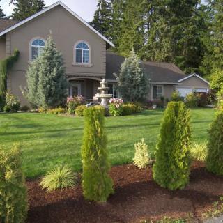 A beautiful house surrounded by a well-maintained garden with lush greenery.