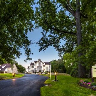 A scenic view of a hotel surrounded by lush trees and a winding driveway.