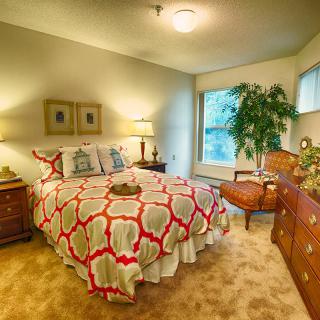 A cozy bedroom with a patterned bedspread, warm lighting, and elegant decor.