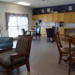 A community kitchen and dining area with several tables and chairs.