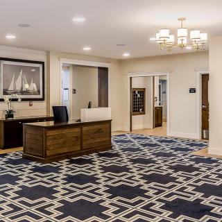 A modern office reception area with a stylish rug and artwork on the wall.