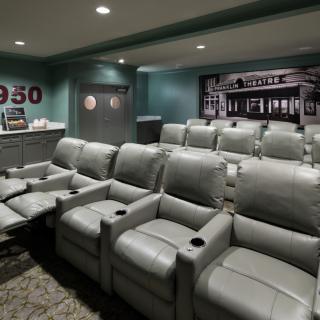 A cozy home theater with comfortable recliner seating and a vintage cinema theme.