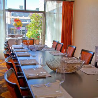 A modern dining room with a large table elegantly set for a gathering.