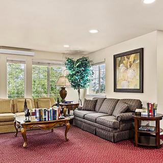 A cozy living room with comfortable seating, a coffee table, and decorative elements like artwork and plants.