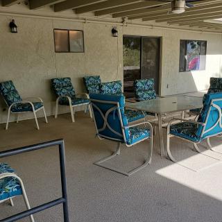 A cozy outdoor patio with chairs and tables for relaxing.