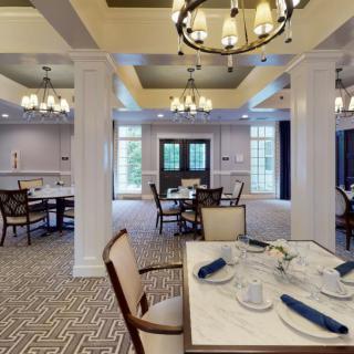 An elegant dining area with chandeliers, neatly arranged tables, and sophisticated dcor.
