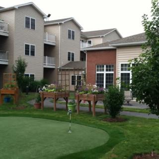 A residential complex with a putting green and landscaped outdoor area.
