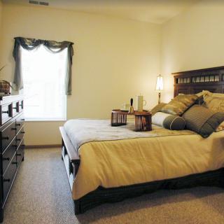A cozy bedroom with a neatly made bed, soft lighting, and elegant decor.