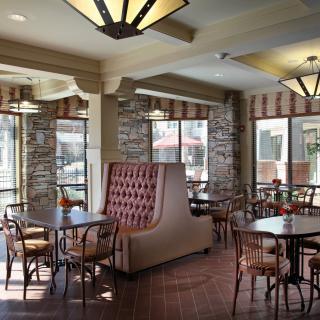 A cozy cafe interior with booth and table seating, featuring large windows allowing natural light to fill the space.