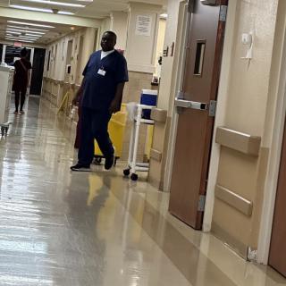 A nurse walks down a hospital corridor.