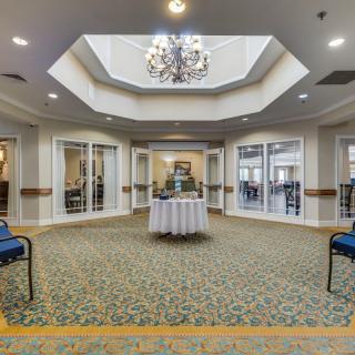 A spacious lobby area with a chandelier and seating arrangements.