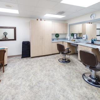 A well-lit barbershop interior with styling chairs and mirrors.