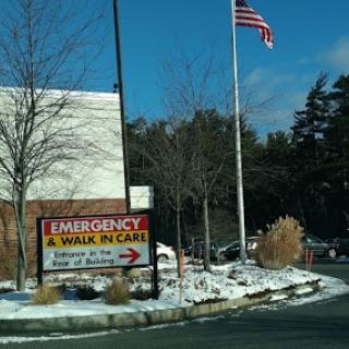 Sign directing to emergency and walk-in care services outside a medical facility.