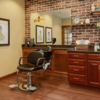 A cozy barber shop interior with a vintage-style barber chair, brick wall, and neatly organized shelves.