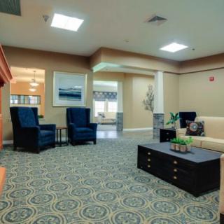 A cozy living room with seating arrangements, a decorative carpet, and warm lighting.